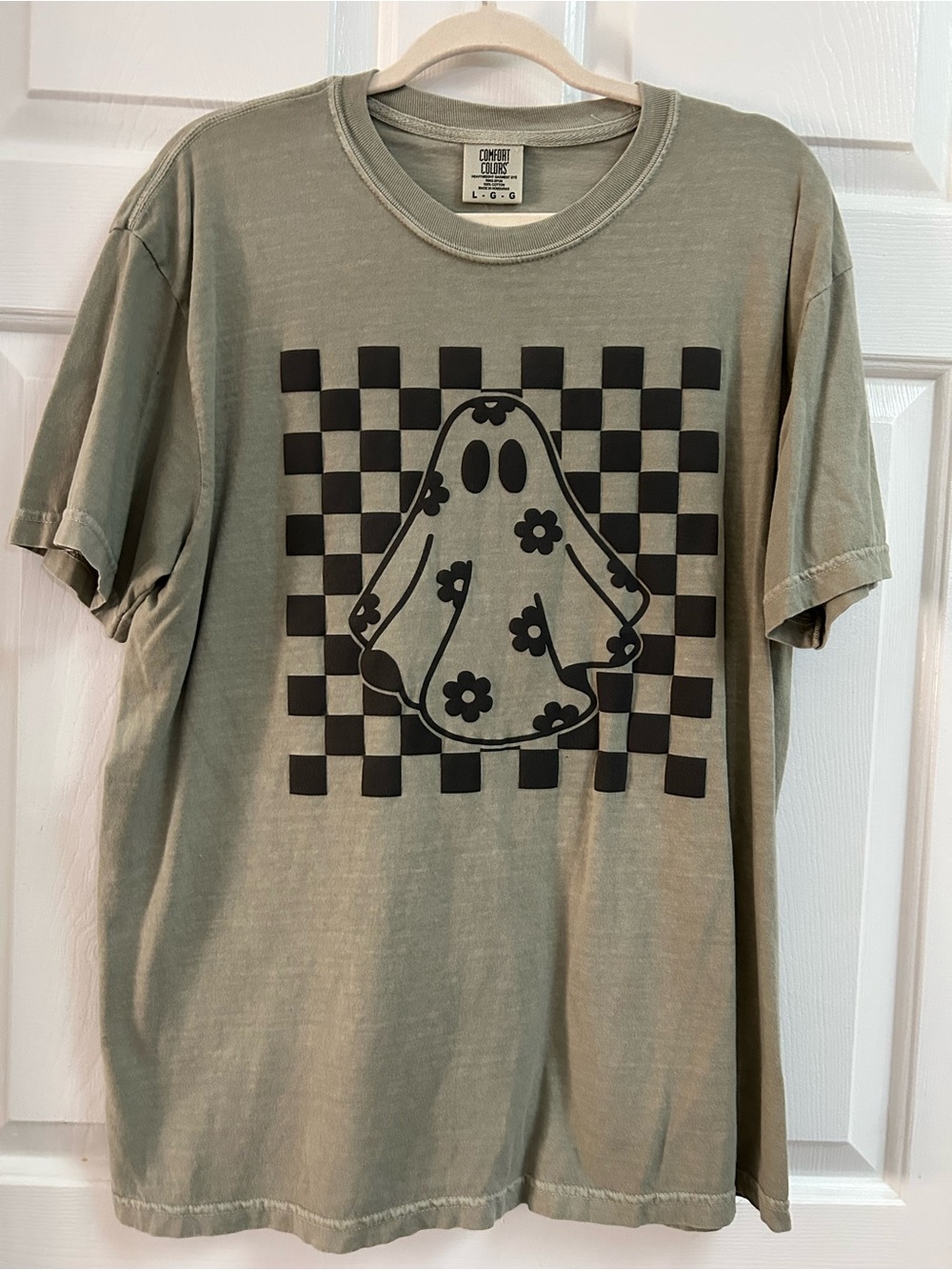 Comfort Colors Olive Womenโs Tee with Black Checker Ghost Graphic